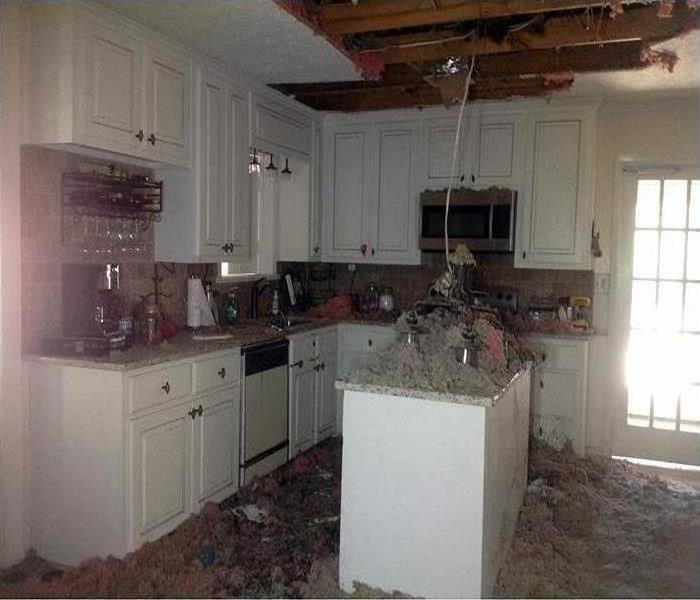 kitchen with fallen ceiling and light fixture after fire damage