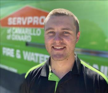 Portrait of Garret, male employee, in front of green truck